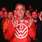 Canada's Prime Minister Mark Carney applauds as he stands next to supporters during an event at the Liberal Party election night headquarters.