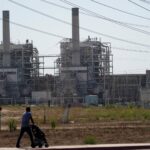 A man pushes a stroller near the AES power plant in Redondo Beach, California