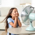 Gadis kecil menikmati kipas angin yang keren