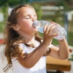 Gadis Kecil Minum Air Dari Botol Plastik