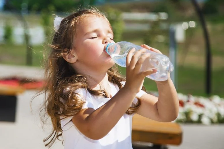 Gadis Kecil Minum Air Dari Botol Plastik